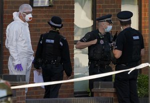 Police officers talk at the scene outside the Belfairs Methodist Church in Eastwood Road North, where British Conservative lawmaker David Amess has died after being stabbed at a constituency surgery, in Leigh-on-Sea, Essex, England, Friday, Oct. 15, 2021