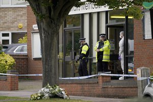 A forensic police officer speaks with a police officer at the Belfairs Methodist Church where member of Parliament David Amess was killed on Friday during a meeting with constituents at the church, in Leigh-on-Sea, Essex, England, Saturday, Oct. 16, 2021.