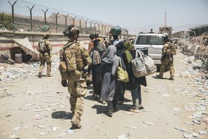 In this photo provided by the U.S. Marine Corps, Italian coalition forces assist and escort evacuees for onward processing during an evacuation at Hamid Karzai International Airport in Kabul, Afghanistan, Tuesday, Aug. 24, 2021.