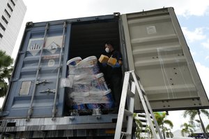 Thai Customs officials unload seized heroin for display during a press conference at the Customs headquarters in Bangkok, Thailand, Tuesday, July 6, 2021.