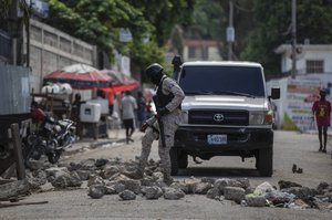 Police remove a roadblock set by protesters in Port-au-Prince, Haiti, Monday, Oct. 18, 2021