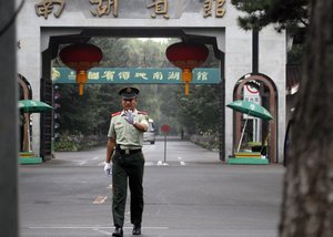 A Chinese paramilitary police man gestures for a photographer to stop shooting pictures outside the Nan Hu hotel where North Korean leader Kim Jong Il is believed to be staying