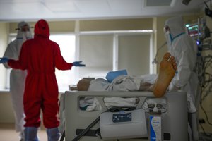 Medics wearing special suits to protect against coronavirus make a briefing as they come to treat a patient with coronavirus at an ICU at the Moscow City Clinical Hospital 52, in Moscow, Russia, Tuesday, Oct. 19, 2021