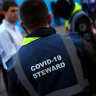 A COVID-19 steward monitors the crowds before a UEFA Champions League match in London last week.