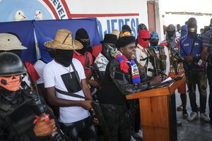 Barbecue, the leader of the "G9 and Family" gang, gives a speech alongside his group's members as he leads a march against kidnapping in La Saline neighborhood of Port-au-Prince, Haiti, Friday, Oct. 22, 2021