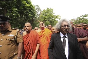 Sri Lankan Buddhist monk Galagodaatte Gnanasara, center wearing spectacles, leaves with his lawyers and supporters after obtaining bail following his surrender to a magistrate in Colombo, Sri Lanka, Wednesday, June 21, 2017.