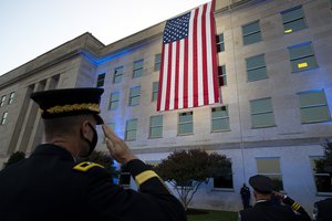 File - Officers salute an American flag unfurled over the side of the Pentagon at sunrise on the 20th anniversary of the 9/11 terrorist attacks at the Pentagon September 11, 2021 in Arlington, Va.