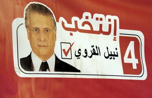 A poster of the owner of the Tunisian private channel Nessma TV, Nabil Karoui is set up during a press conference in Tunis