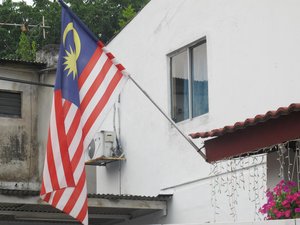 The flag of Malaysia, also known as the Jalur Gemilang was hang on a roof of a house in Kuala Lumpur, Malaysia.