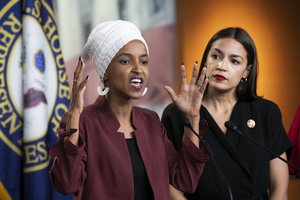 File - Rep. Ilhan Omar, D-Minn., joined at right by Rep. Alexandria Ocasio-Cortez, D-N.Y., responds to base remarks by President Donald Trump after he called for four Democratic congresswomen of color to go back to their "broken? countries, as he exploited the nation’s glaring racial divisions once again for political gain, during a news conference at the Capitol in Washington, Monday, July 15, 2019.