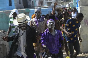 People believed to be possessed with the Gede spirit hold a ceremony honoring the Haitian Vodou spirit of Baron Samedi and Gede at the National Cemetery in Port-au-Prince, Haiti, Monday, Nov. 1 2021