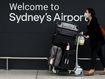 A traveller pushes a luggage cart outside the departure hall of the international terminal of Sydney Airport in Sydney.