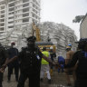 Rescue workers are seen at the site of a collapsed 21-storey apartment building under construction in Lagos, Nigeria, on Tuesday AEDT.