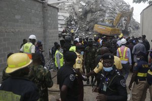 Security force gather as rescue personel work at the site of a collapsed 21-story apartment building under construction in Lagos, Nigeria, Monday, Nov. 1, 2021