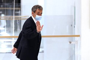 Former French President Nicolas Sarkozy, right, leaves the courtroom, Monday, Nov. 23, 2020 in Paris