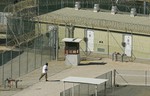 File - In this photo, reviewed by a U.S. Department of Defense official, a Guantanamo detainee, center left, jogs around the exercise area at the medium security portion of Camp Delta detention facility, at the Guantanamo Bay U.S. Naval Base, Cuba, Thursday, Sept. 21, 2006.