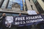 File - Demonstrators stand outside Westminster Magistrates Court in support of WikiLeaks founder Julian Assange, who is due to appear for an administrative hearing, in London, Monday, Jan. 13, 2020.