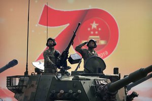 In this Oct. 1, 2019, file photo, Chinese tank crew members salute during a parade to commemorate the 70th anniversary of the founding of Communist China in Beijing