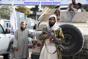 Taliban fighters stand guard in front of the Hamid Karzai International Airport after the U.S. withdrawal in Kabul, Afghanistan, Tuesday, Aug. 31, 2021