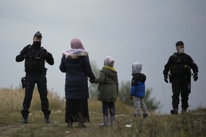 Police officers patrol near a migrant camp in Calais, northern France, Thursday, Oct. 14, 2021.