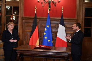 German Chancellor Angela Merkel reacts as French President Emmanuel Macron applauds as she is awarded with the Grand Cross of the Legion d'Honneur, in Beaune, Burgundy, Wednesday Nov. 3, 2021