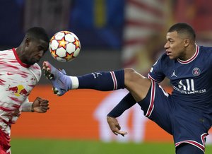 PSG's Kylian Mbappe, right, duels for the ball with Leipzig's Nordi Mukiele during the Group A Champion's League soccer match between RB Leipzig and Paris Saint Germain at the Red Bull Arena in Leipzig, Germany, Wednesday, Nov. 3, 2021