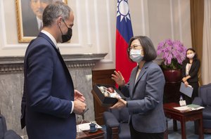 In this photo released by the Taiwan Presidential Office, Taiwan's President Tsai Ing-wen, right presents a gift to Raphael Glucksmann, the chair of the EU's foreign interference committee during a meeting in Taipei, Taiwan on Thursday, Nov. 4, 2021.