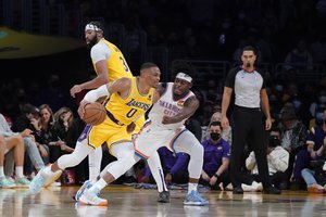 Los Angeles Lakers guard Russell Westbrook (0) dribbles around Oklahoma City Thunder forward Luguentz Dort during the second half of an NBA basketball game Thursday, Nov. 4, 2021, in Los Angeles