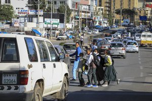 Schoolchildren cross traffic as they return home from school in the Piazza old town area of the capital Addis Ababa, Ethiopia Thursday, Nov. 4, 2021