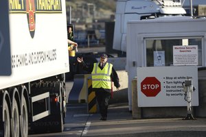 File - A lorry driver hands over documents at a security checkpoint at the port of Larne, Northern Ireland, Saturday, Dec. 12, 2020, situated north of Belfast handling freight and travel for the two hour crossing of the Irish Sea between Scotland and Northern Ireland.