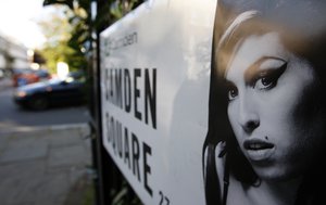 A picture of singer Amy Winehouse is seen stuck to an address sign as a car drives past it near the residence of Winehouse in Camden Square, north London, Sunday, July 24, 2011.