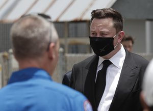 CEO of SpaceX, Elon Musk, talks to the media and NASA personnel, after astronauts Douglas Hurley, left, and Robert Behnken