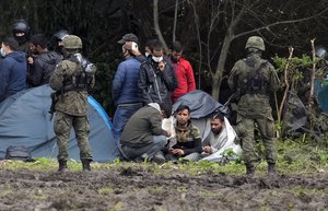 Polish security forces surround migrants stuck along with border with Belarus in Usnarz Gorny, Poland, on Wednesday, Sept. 1, 2021