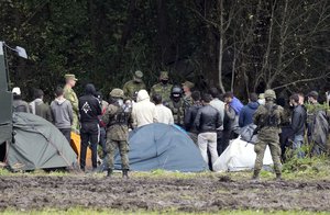 Polish security forces surround migrants stuck along the border with Belarus in Usnarz Gorny, Poland, on Wednesday, Sept. 1, 2021.