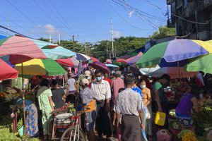 People walk through a crowded street market Sunday, Oct. 24, 2021 in Yangon, Myanmar.