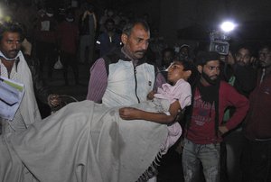 A man carries a child out from the Kamla Nehru Children’s Hospital after a fire in the newborn care unit of the hospital killed four infants, in Bhopal, India, Monday, Nov. 8, 2021.