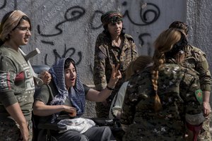 A Kurdish fighter who was injured while fighting against Islamic State militants, flashes the victory sign as she protests with her comrades against an anticipated Turkish incursion targeting Syrian Kurdish fighters, in front the United Nations building, in Qamishli, northeast Syria, Monday, Oct. 8, 2019.