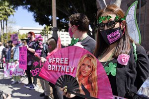 File - Britney Spears supporter Kiki Norberto holds a hand fan outside a court hearing concerning the pop singer's conservatorship at the Stanley Mosk Courthouse, Wednesday, March 17, 2021, in Los Angeles.