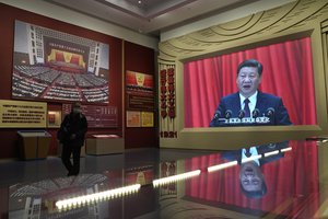 Chinese President Xi Jinping's image on a big screen is reflected on glass at the Museum of the Communist Party of China here in Beijing, China, Friday, Nov. 12, 2021.