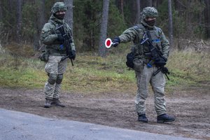 Lithuanian soldiers patrol a road near the Lithuania-Belarus border near the village of Jaskonys, Druskininkai district some 160 km (100 miles) south of the capital Vilnius, Lithuania, Saturday, Nov. 13, 2021