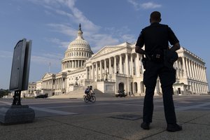 The U.S. Capitol is seen in Washington, early Tuesday, July 27, 2021, as U.S. Capitol Police watch the perimeter.