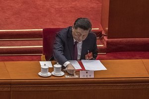 Chinese President Xi Jinping presses a button to vote on a proposal to draft changes of election rules for Hong Kong during the closing session of the National People's Congress (NPC), at the Great Hall of the People, in Beijing Thursday, March 11, 2021