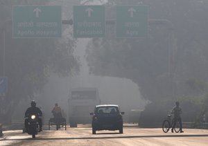 A motorcyclist drives on the wrong side of the road amidst morning haze and toxic smog in New Delhi, India, Wednesday, Nov. 17, 2021.