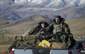 Ethnic Armenian soldiers ride a car passing the border between Nagorno-Karabakh and Armenia near Vardenis, Sunday, Nov. 8, 2020