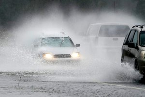 A westbound car is caught in a spray of water thrown up by a pickup truck on Highway 20 Monday, Nov. 15, 2021, near Hamilton