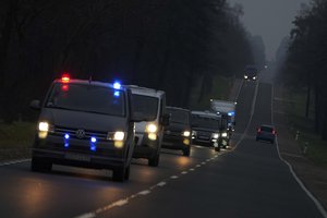 Polish police cars drive back from the border with Belarus near Kuznica, Poland, Tuesday, Nov. 16, 2021