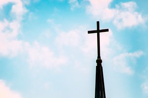 A cross of a church is seen in this photo.