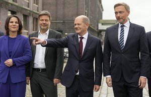 Social Democratic Party, SPD, chancellor candidate Olaf Scholz, second right, stands with the Green party leaders Annalena Baerbock, left, and Robert Habeck, second left, and the Free Democratic Party chairman Christian Lindner, right, as they arrive for a joint news conference in Berlin, Germany, Wednesday, Nov. 24, 2021.