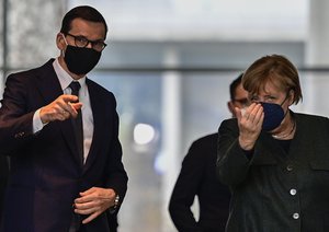 German Chancellor Angela Merkel, right, and Prime Minister of Poland Mateusz Morawiecki arrive for a press statement after talks at the chancellery in Berlin, Germany, Thursday, Nov. 25, 2021.