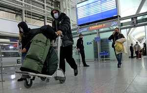 Iraqi migrants arrive to the airport in Irbil, Iraq, early Friday, Nov. 26, 2021.